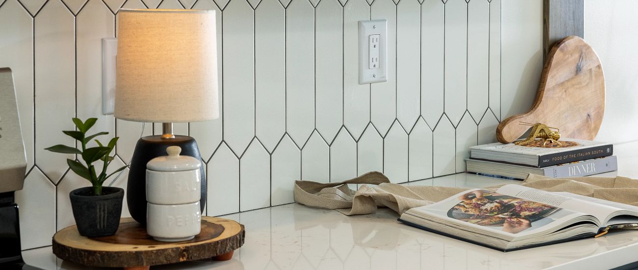 Countertop with lamp and white picket tile backsplash